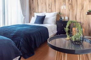 a bedroom with a bed and a glass table at Villa Penthouse Tenma in Osaka