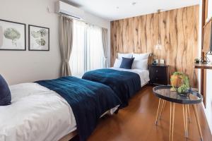 a hotel room with two beds and a table at Villa Penthouse Tenma in Osaka