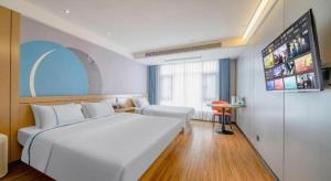 a hotel room with a white bed and a flat screen tv at City Comfort Inn Zhanjiang Xuwen Port Wharf Passenger Station in Xuwen +228 photos