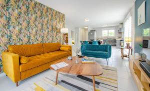 BréviandesにあるLe fairwayの黄色いソファとテーブルのあるリビングルーム