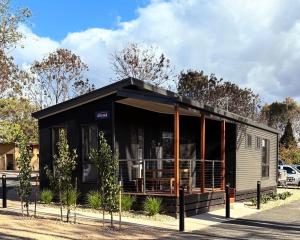 a black tiny house on display in a parking lot at BIG4 Rutherglen Holiday Park in Rutherglen