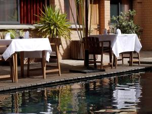a table and chairs next to a pool of water at Hotel Sakamanga in Antananarivo