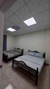two beds in a room with a ceiling at Baruna Homestay in Wutai