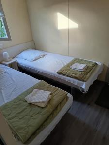 two beds in a room with a mirror at CAMPING LE CLOS DU THYM in Argelès-sur-Mer