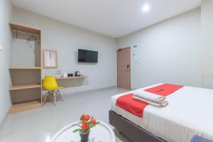 una camera con letto, tavolo e sedia gialla di Sans Stay Karapitan Street a Bandung