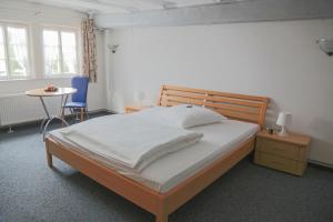 1 dormitorio con 1 cama grande y 1 mesa en Hotel Haus Landgraf, en Walldorf