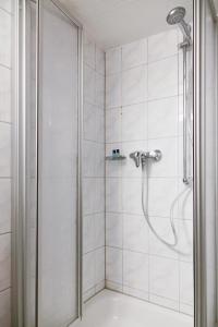 a shower with a shower head in a bathroom at Hotel Haus Landgraf in Walldorf