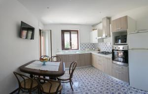 een keuken met een tafel en stoelen en een koelkast bij Archimede Lounge in Cefalù