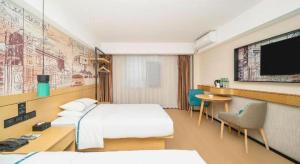 a hotel room with two beds and a flat screen tv at City Comfort Inn Dali High-speed Railway Station Erhai Park in Dali