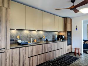 une cuisine avec des armoires en bois et un évier dans l'établissement La villa Blue Banian, à Saint-Pierre