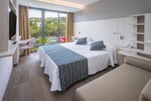 una habitación de hotel con una cama y un balcón en GHT Sa Riera, en Tossa de Mar