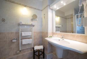 ein Bad mit einem Waschbecken und einem Spiegel in der Unterkunft Logis Auberge de la Rose in Doué-la-Fontaine