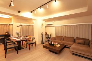 een woonkamer met een bank en een tafel bij Modern Tokyo Suites in Tokyo