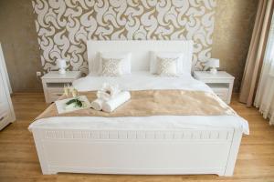 um quarto com uma cama branca com duas mesas de cabeceira em Villa Grande - Apartmány em Olomouc