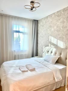 a bedroom with a white bed with two towels on it at High-end, New, 2 Bedroom at primary location, every comfort you need in Ulaanbaatar