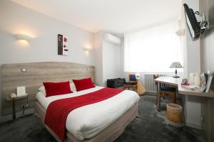 a hotel room with a large bed with red pillows at Logis Auberge de la Rose in Doué-la-Fontaine