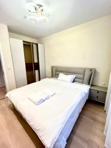 a white bed with two white towels on it at High-end, New, 2 Bedroom at primary location, every comfort you need in Ulaanbaatar