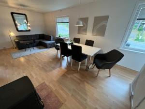 a living room with a table and chairs and a couch at Central trainstation apartment in Narvik