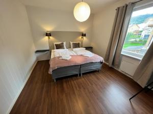 a bedroom with two beds and a large window at Central trainstation apartment in Narvik