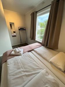 a bed in a room with a window at Central Trainstation Apartment with free Parking in Narvik