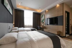 a hotel room with two beds and a flat screen tv at Thank Inn Hotel Guangdong Jiangmen Kaiping Donghui City in Jiangmen