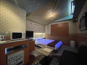 a hotel room with a bed and a tv at HOTEL Bew Rose Mary in Kai