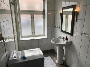 a bathroom with a sink and a toilet and a mirror at Central Narvik Apartment Walk to Train Bus in Narvik