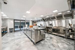 a large commercial kitchen with stainless steel appliances at Studio 8 Residences - Adults Only in Sydney