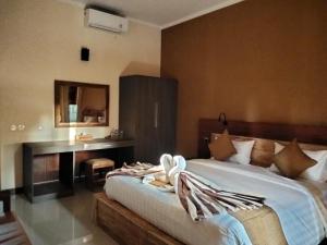 a bedroom with a bed and a desk in it at C'man Guest House in Mantaak +67 photos