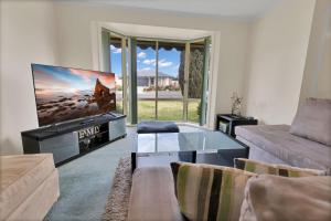 a living room with a flat screen tv and a couch at Villa Victoria in Paynesville