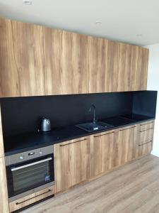 a kitchen with a black counter top and wooden cabinets at 3-izbový byt in Prievidza