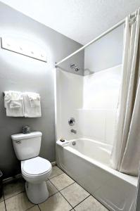 a white bathroom with a toilet and a bath tub at Okanagan Seasons Resort in Kelowna +19 photos