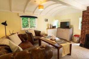 un salon avec un canapé en cuir et une table dans l'établissement Railway Carriages, à Hinton Admiral Station 10 autres photos