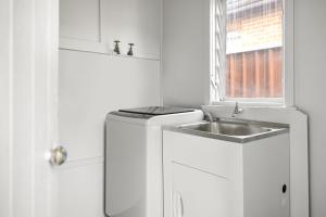 a white kitchen with a sink and a window at Budget Single Room in Belmore - Convenient Stay Near Shops - Shared Bathroom in Sydney