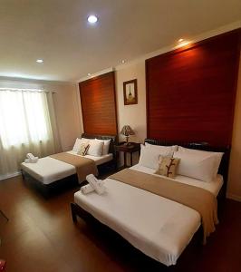 a hotel room with two beds and a window at El Casa Azul in Amadeo +27 photos