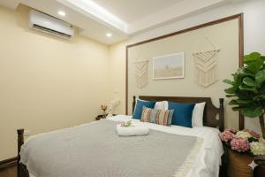 a bedroom with a large bed with blue pillows at Lunaria Two Bedroom Apartment in Hanoi