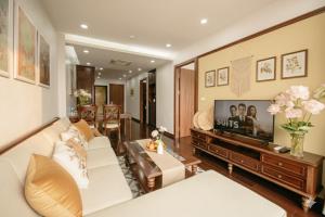 a living room with a couch and a tv at Lunaria Two Bedroom Apartment in Hanoi