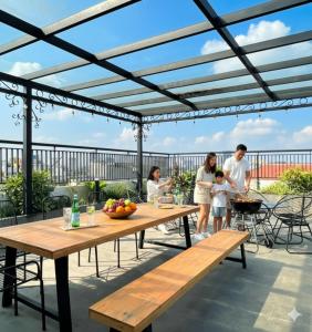 a family standing on a patio with a pergola at Lunaria Two Bedroom Apartment in Hanoi