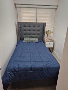 Un dormitorio con una cama azul con un edredón azul. en Modern Apartment in Barranco with a Pool, en Lima 17 fotos más