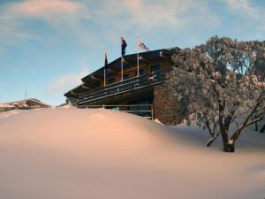 een gebouw bovenop een met sneeuw bedekte heuvel bij Ski Club of Victoria - Ivor Whittaker Lodge in Mount Buller
