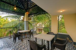 a restaurant with tables and chairs and windows at Calangute Beach Home Away in Calangute