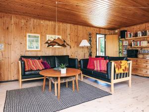 a living room with two black couches and a table at 6 person holiday home in Rømø in Bolilmark