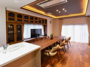 a large kitchen with a long table and chairs at Kazeno Ryoan Fuga-風乃旅庵 楓雅 in Koshu