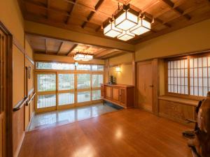 a large room with wooden floors and a large window at Kazeno Ryoan Fuga-風乃旅庵 楓雅 in Koshu