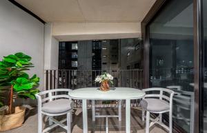 a table and chairs with a vase of flowers on a balcony at Cosy 2BR in Reid with free wifi n parking in Canberra