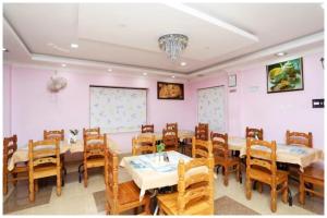 a dining room with pink walls and wooden tables and chairs at Hotel New Sambit International Near Sea Beach And Jagannath Temple in Puri