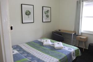 a bedroom with a bed with towels on it at Courthouse Hotel Gunnedah in Gunnedah
