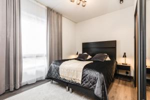 een slaapkamer met een bed en een groot raam bij Levi Cranberry C 13 ski-in ski-out Visit Levi in Levi