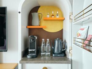 a kitchen with a shelf with a coffee maker at Canopy By Hilton Osaka Umeda in Osaka
