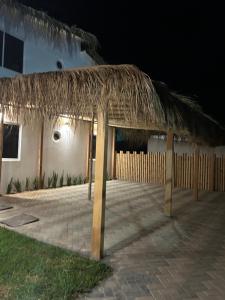 un edificio con techo de paja y patio en Dunamar Beach House, en Los Órganos 34 fotos más